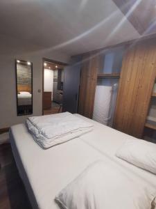 - une chambre dotée d'un lit avec des draps blancs dans l'établissement Très beau T2 idéalement situé Tignes Val Claret, à Tignes