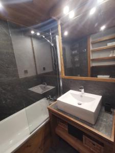 La salle de bains est pourvue d'un lavabo, d'un miroir et d'une baignoire. dans l'établissement Très beau T2 idéalement situé Tignes Val Claret, à Tignes