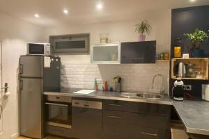 a kitchen with a refrigerator and a sink at Duplex Cosy : Moderne, Fonctionnel et Confortable in Lans-en-Vercors