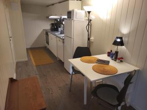una pequeña cocina con mesa y nevera en Sokkelleilighet rett ved Saltstraumen, en Bodø