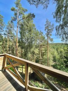 a wooden deck with a view of the woods at Anika dom w lesie nad jeziorem Słupinko in Dziemiany