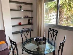 a glass table and chairs in a room with a window at Seaside apartment with balcony in Las Galletas