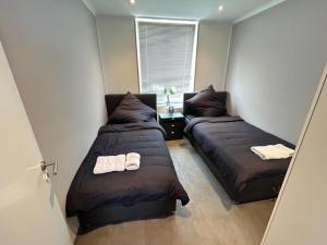 1 dormitorio con 2 camas y ventana en City Apartment Paderborn Apartment 6, en Paderborn