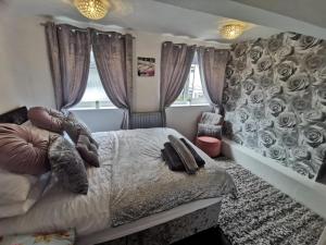 a bedroom with a bed and a wall with roses at Stunning 2-Bed House in Macclesfield Cheshire in Macclesfield