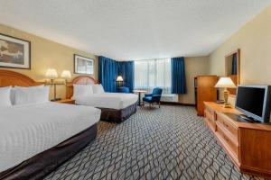 a hotel room with two beds and a flat screen tv at Clarion Hotel Anaheim Resort in Anaheim