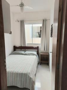 Habitación pequeña con cama y ventana en Apartamento novo 450 mt da praia Ingleses, en Florianópolis