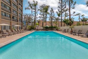 a swimming pool at a hotel with lounge chairs at Clarion Hotel Anaheim Resort in Anaheim