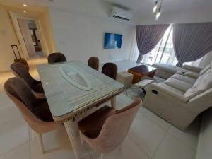 een woonkamer met een tafel en stoelen en een bank bij Marassi Marina in El Alamein