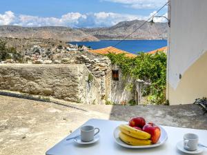 a plate of fruit on a table with a view at Athanasia's House in Symi