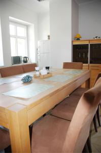 a kitchen with a wooden table with chairs at Eko Marina Mikolajki in Mikołajki