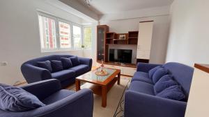 ein Wohnzimmer mit 2 blauen Stühlen und einem Tisch in der Unterkunft 4M Apartments in Ohrid