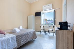 Habitación con 2 camas, mesa y ventana en Bonnystudios Holiday Apartments en Cagliari