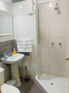 een witte badkamer met een douche en een wastafel bij Cozy Family Full Apartament Excelent WIFI in Lima