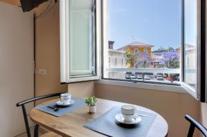 una mesa con dos tazas delante de una ventana en Bonnystudios Holiday Apartments en Cagliari