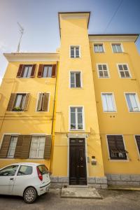 un edificio amarillo con un coche aparcado delante de él en Bonnystudios Holiday Apartments en Cagliari