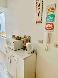 een magnetron op een aanrecht in een keuken bij Cozy Family Full Apartament Excelent WIFI in Lima