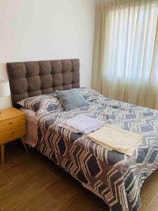 een slaapkamer met een bed, een nachtkastje en een raam bij Cozy Family Full Apartament Excelent WIFI in Lima