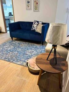 een woonkamer met een blauwe bank en een tafel met een lamp bij Cozy Family Full Apartament Excelent WIFI in Lima