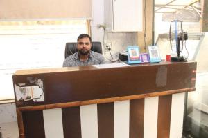 Un uomo seduto ad una scrivania in un ufficio di Hotel O Food Plaza a Zirakpur