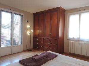 a bedroom with a bed and a dresser and windows at Casa Mia, chambre privée en Provence in LʼIsle-sur-la-Sorgue