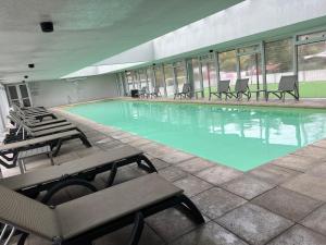 una gran piscina con sillas en un edificio en Apartamento en Ocean Drive Country, en Punta del Este