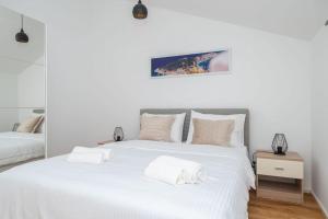 une chambre avec deux lits avec des draps blancs dans l'établissement Villa Nusa - Imotski- Brand new, à Imotski 54 autres photos