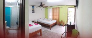 um quarto com 2 camas e uma casa de banho com um chuveiro em Cabinas Smith em Cahuita