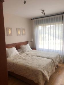 sypialnia z dużym łóżkiem i oknem w obiekcie Apartamento Boutique Arquera Golf II -Llanes w mieście Llanes