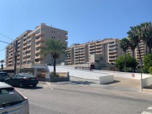 a parking lot with cars parked in front of tall buildings at SERVICE APART LAZARO TOPACIO 3 in Calpe