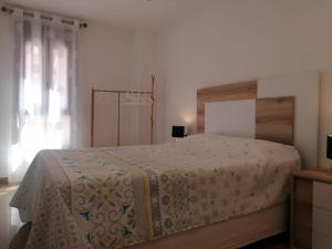 Un dormitorio con una cama grande y una ventana en Apartamento Moya - Playa y Sol, en Aguadulce