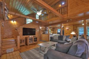 a living room with a couch and a tv in a cabin at Keepin it Reel in Ellijay