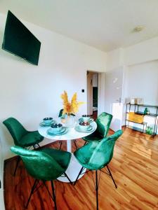 a dining room with a table and green chairs at Ferienwohnung Lucia in Schiefling am See