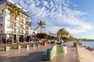 a city street with palm trees and a building at Seven Crown La Paz Malecon in La Paz
