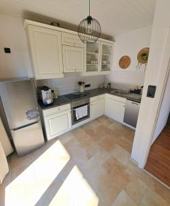 uma cozinha com armários brancos e electrodomésticos de aço inoxidável em Ferienwohnung Lucia em Schiefling am See