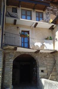 ein Steingebäude mit einem Balkon und einer Tür in der Unterkunft Casa Elisa affittacamere in Armeno