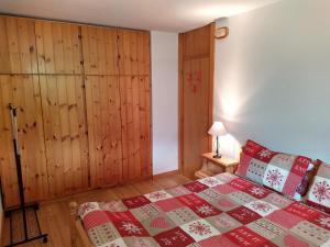 a bedroom with a bed and a wooden wall at Appartamento I Larici in Folgarida