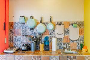a kitchen counter with pots and pans hanging on a wall at Casa Colibrí Malecón in Puerto Vallarta
