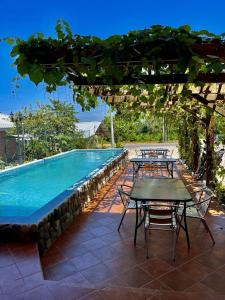 a patio with tables and a swimming pool at Hotel y Restaurante Virgen de Fátima in La Ceiba