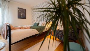 Apartmani Gruzdovo في ديلنايس: غرفة نوم بسرير ونبات