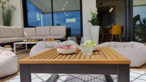 Una mesa de café con tazones de fruta en una sala de estar. en ALLONBAY sea front luxury penthouse, en Villajoyosa