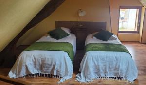 two twin beds in a room with a staircase at GITE LE FOUR DE SULIATUS in Seuillet