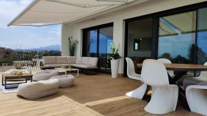 Una sala de estar con sillas blancas y una mesa. en ALLONBAY sea front luxury penthouse, en Villajoyosa