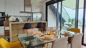 Un comedor con una mesa de cristal y sillas. en ALLONBAY sea front luxury penthouse, en Villajoyosa