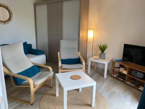 uma sala de estar com duas cadeiras e uma televisão em Studio cosy à saint-Pierre la mer em Fleury
