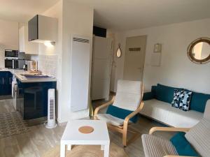 Studio cosy à saint-Pierre la mer في فلوري: غرفة معيشة مع أريكة وطاولة