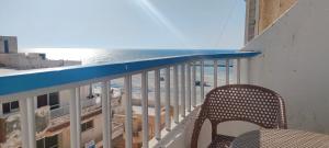 einen Balkon mit einem Stuhl und Meerblick in der Unterkunft العجمى الكيلو 21 شاطئ النخيل in Alexandria