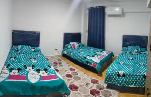 1 Schlafzimmer mit 2 Betten und Hallo-Kätzchen-Betten in der Unterkunft العجمى الكيلو 21 شاطئ النخيل in Alexandria