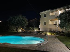 a swimming pool in front of a building at night at Sunny Apartments in Zaton +35 photos