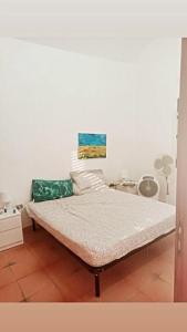 een bed in een kamer met een witte muur bij La Casa dell'Artista in Marconia