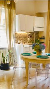a kitchen with a table with two chairs and a table with flowers at Casa Vittorio in Turin